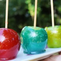 three apples are on a plate with toothpicks in the shape of an apple