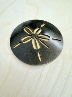 a black and gold dragonfly brooch sitting on top of a wooden table