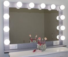 a white vanity mirror sitting on top of a counter