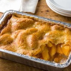 a metal pan filled with food on top of a wooden table