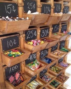 a wooden shelf filled with lots of different types of candies and chocolates in bins