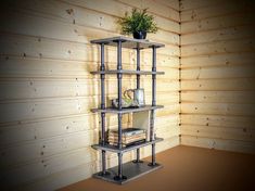 a shelf with books and plants on it in a room that has wood paneled walls