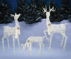 three lighted deer and two baby deer in the snow