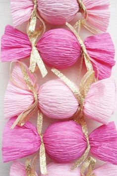 pink balls with gold ribbons and bows on them