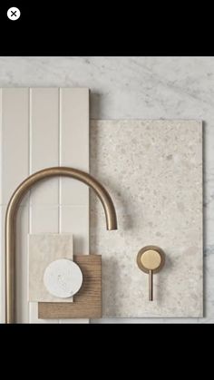 a bathroom with marble tile and brass faucet on the wall, next to a sink