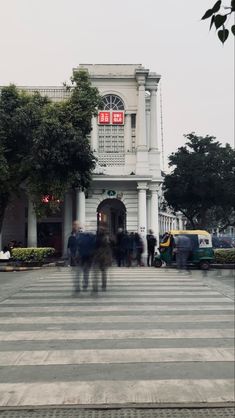 people are walking around in front of a building