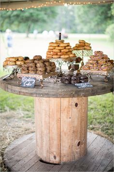 a wooden table topped with lots of donuts and pastries on top of it