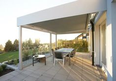 a covered patio with table and chairs on it