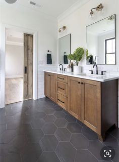 a large bathroom with two sinks and mirrors