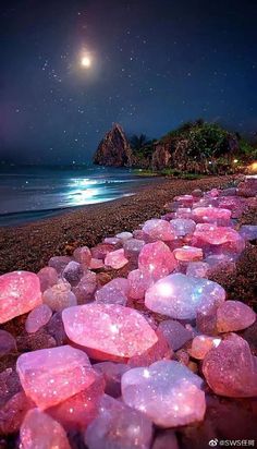 the beach is lined with pink rocks and stars in the night sky, as if it were floating on water