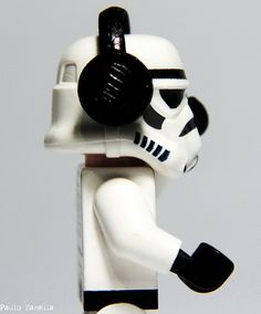 a lego star wars character holding a black and white helmet on his head with one hand