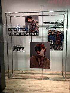 a glass display case with photos of people in the background and words written on it