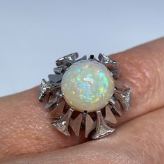 a woman's ring with an opal in the center