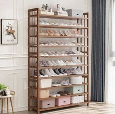 the shoe rack has many pairs of shoes on it and is in front of a window