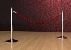 a red carpeted area with two poles and a rope