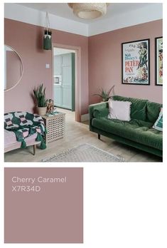 a living room with pink walls and green furniture