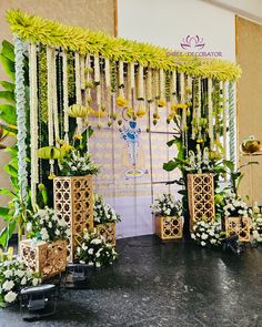 an arrangement of flowers and greenery on display in front of a stage set up