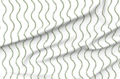 a ruler with green wavy lines on white fabric, as well as the measurements for each piece