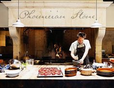 a man in an apron preparing food on a table