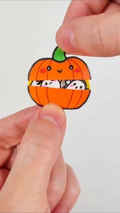 someone is holding a sticker with an image of a pumpkin in the shape of a cat