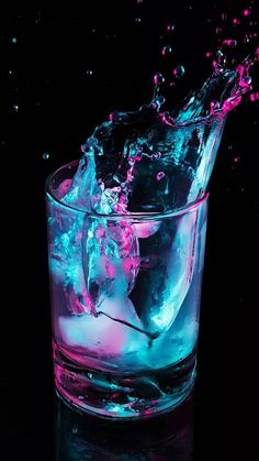 a glass filled with ice and water on top of a table