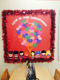 a bulletin board with the words love is our super power on it and balloons in the air