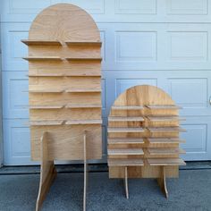 two wooden bookshelves sitting next to each other in front of a garage door