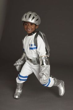 a young boy dressed in white and silver