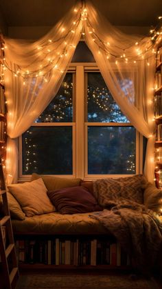 a window with lights hanging from it and a couch in front of the windowsill