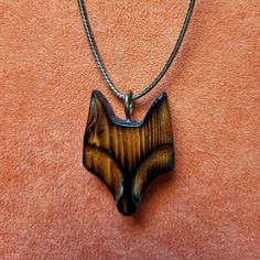 Capture the enchanting allure of the fox with our handcrafted wood carved pendant. Crafted with precision, this whimsical accessory adds a touch of nature-inspired charm to any look. Perfect for lovers of wildlife and unique jewelry alike. (Chord Color may vary) Handmade Natural Wood Pendant Jewelry, Engraved Brown Necklace For Gift, Artisan Wood Jewelry Gift, Artisan Wooden Jewelry As A Gift, Natural Wood Pendant Jewelry For Gifts, Natural Wood Pendant Jewelry Gift, Natural Wood Pendant Jewelry As Gift, Handmade Wooden Necklace Gift, Artisan Natural Wood Necklace As A Gift