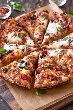 a sliced pizza sitting on top of a wooden cutting board