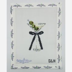 a cross stitch picture with a martini glass on it