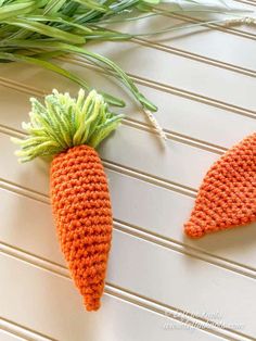 two crocheted carrots sitting next to each other