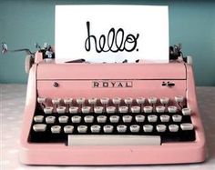 an old pink royal typewriter sitting on a table with a note attached to it