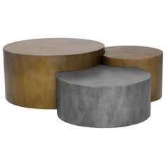 two tables made out of concrete and gold colored metal, one with a round table top