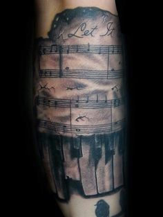 a man's arm with music notes on it and an image of a piano