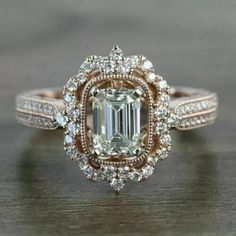 an emerald colored diamond surrounded by white and brown diamonds on top of a wooden table