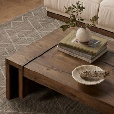 a coffee table with books and a vase on it