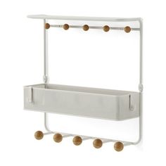 a white wall mounted shelf with three balls hanging from it's sides and two hooks on