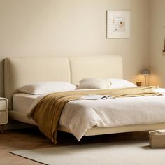 a white bed sitting in a bedroom on top of a hard wood floor