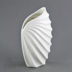 a white vase sitting on top of a table