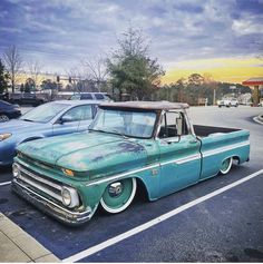 an old pick up truck parked in a parking lot