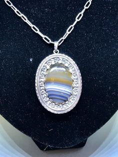 This stunning oval Art Nouveau pendant is an original hand made, one-of-a-kind beauty, circa 1910. This large banded agate is set in a beautiful sterling silver mounting with a reposee flower and leaf boarder. The detailing is exceptional. This pendant is shown on a newer sturdy solid silver link chain (not the original chain). The closure is a modern lobster clasp, strong and secure. Chain is listed separately. The pendant measures 5cm x 4cm. The large banded agate oval measures 3 1/2 x 2 1/2. Antique Oval Cabochon Gemstone Necklaces, Victorian Gemstone Oval Pendant Necklace, Victorian Oval Pendant Necklace With Gemstone, Victorian Gemstone Necklace With Oval Pendant, Victorian Oval Pendant Gemstone Necklace, Ornate Oval Cabochon Necklaces, Formal Oval Agate Necklace, Antique Oval Necklace With Natural Stones, Victorian Jewelry With Large Oval Pendant