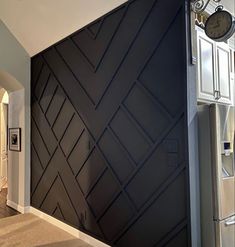 a room with a large black wall and white cupboards in it's center