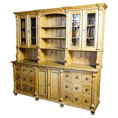 an old wooden cabinet with glass doors and drawers