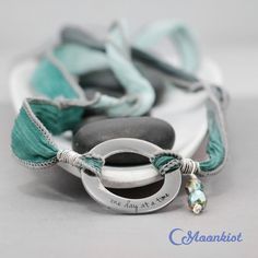 "This Steel and Silk Wrap bracelet features a Steel ring with an engraving that reads \"one day at a time.\" The ring measures 20 mm (approximately .75 inches) in diameter and is attached to silk ribbon that measures 38 inches (approximately 96.5 cm) in length. The hand dyed silk ribbon is sewn on the edge to prevent fraying and attached with Sterling Silver wire. Silk Wrap Bracelets are easy to wear. Just wrap the silk ribbon around your wrist, slide the ring where you want it, and tie the ribb Full Moon Jewelry, Moon Phases Bracelet, Moon Phase Jewelry, Silk Wrap Bracelets, Health Bracelet, Hand Dyed Silk Ribbon, Silk Bracelet, Boho Wrap Bracelet, Inspirational Bracelets