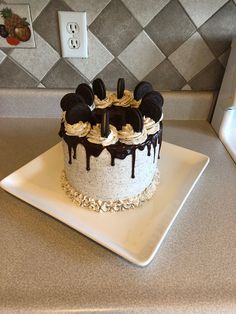 a mickey mouse cake on a white plate with chocolate sauce dripping down the top and ears