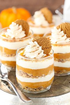 three desserts are sitting on a plate with spoons and oranges in the background