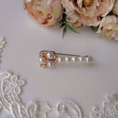 a close up of a brooch with flowers in the background