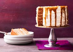 a cake with white frosting and caramel drizzle on top sits next to a plate